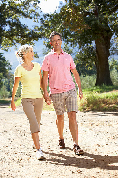 istock Middle Aged Couple Walking Through Countryside 166409218