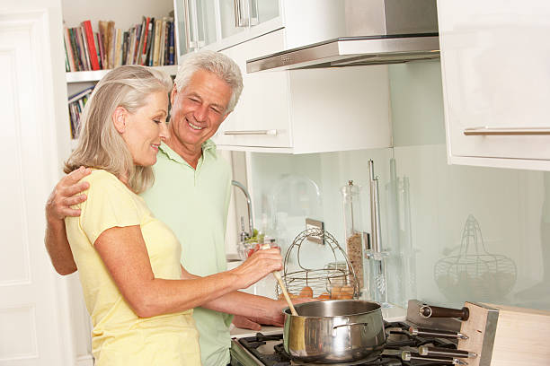 istock Senior Couple Preparing Meal At Cooker 166410048