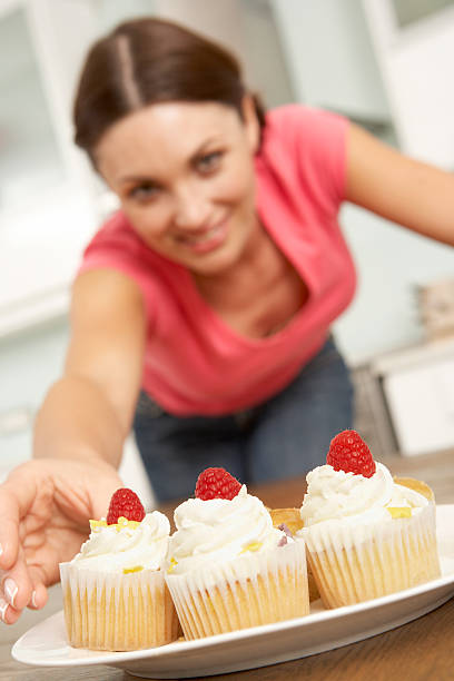 istock Woman Eating Cakes In Kitchen 166410137