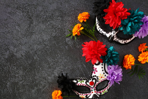石のテーブルでの死者の日やディア・デ・ロス・ムエルトスのメキシコの休日のお祝いのための砂糖の頭蓋骨マスク。