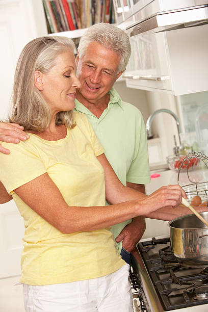 istock Senior Couple Preparing Meal At Cooker 166410196