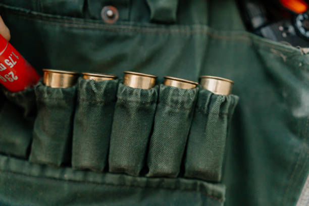 A close-up of a hunter putting bullets into his vest, before going on a hunt.