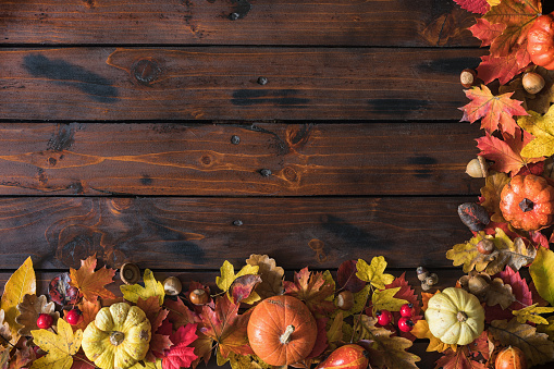 Decorated autumn background with pumpkins and leaves on the wooden background