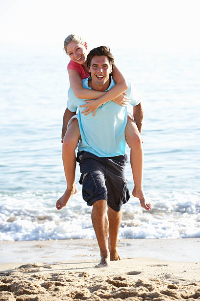 istock Young Couple Enjoying Piggyback On Beach Holiday 166411532