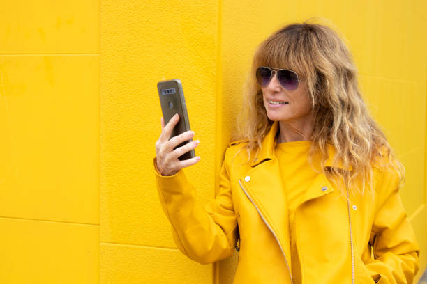 istock middle aged urban woman with mobile phone 1664117963