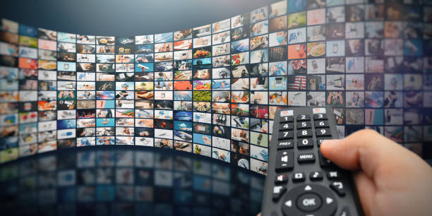Multiple television screens with remote control stock photo