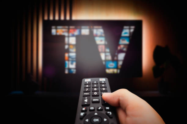 istock Man watching TV with remote control in hand. 1664159099