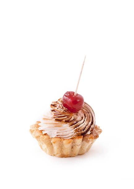 Delicious pastry with cream, caramel and one cherry on white background