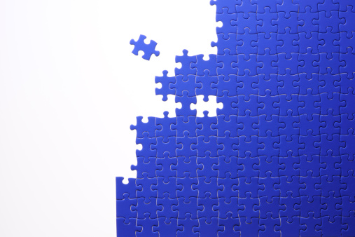Blue jigsaw puzzle against white background with copy space.