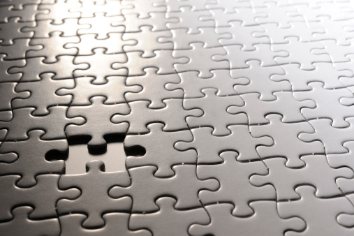 Close-up of missing piece of blank white Jigsaw puzzle.
