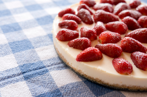 homemade lemon cheesecake with strawberries on the table