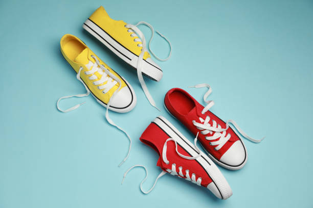 istock Red and yellow classic old school sneakers on light blue background, flat lay 1664170638