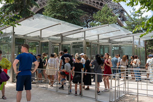 Paris, France - circa July 2023: Tourists in line waiting to visit the Eiffel Tower in Paris, France.