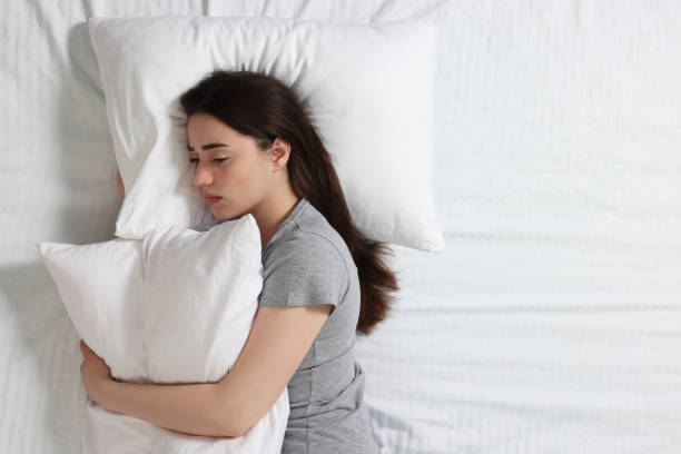 istock Young woman suffering from insomnia on bed, top view. Space for text 1664208491