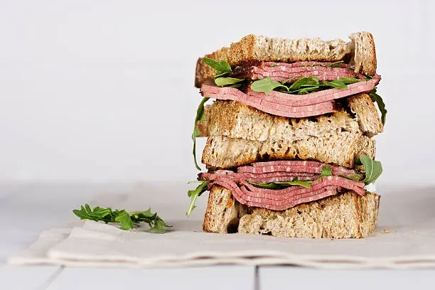Pastrami sandwich on white wood table