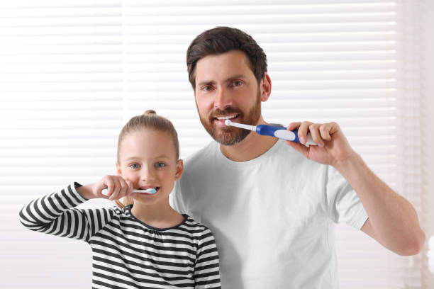 istock Father and his daughter brushing teeth together indoors 1664232893