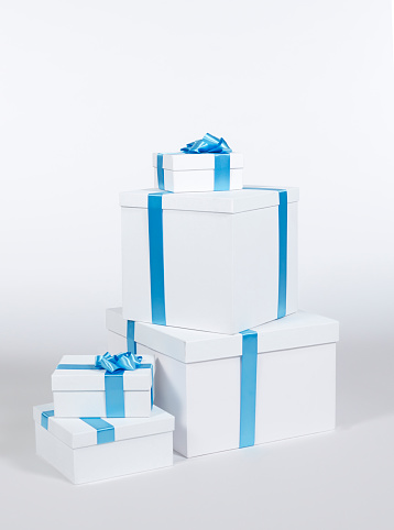 Gift boxes on a white background. Gift boxes tied with blue ribbon. Handmade blue ribbon bows. No people.