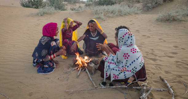 istock Indian kids setting up bonfire on sand dune 1664289489