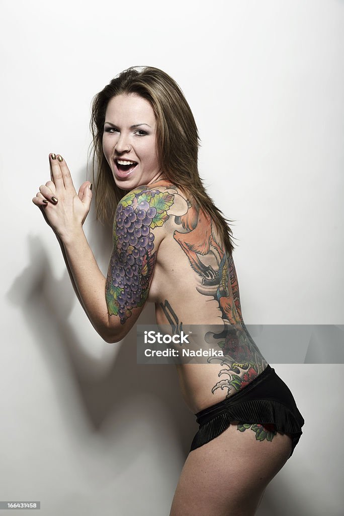 Женщина с в виде тату на спине играет gangster - Стоковые фото Татуировка роялти-фри