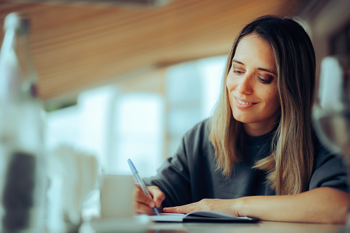 Busy freelance worker keeping a diary and an idea list anywhere she goes