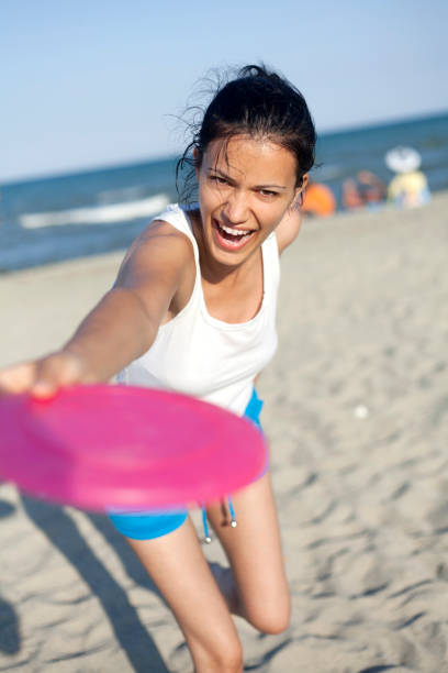 istock young woman playing beach Frisbee 166438856