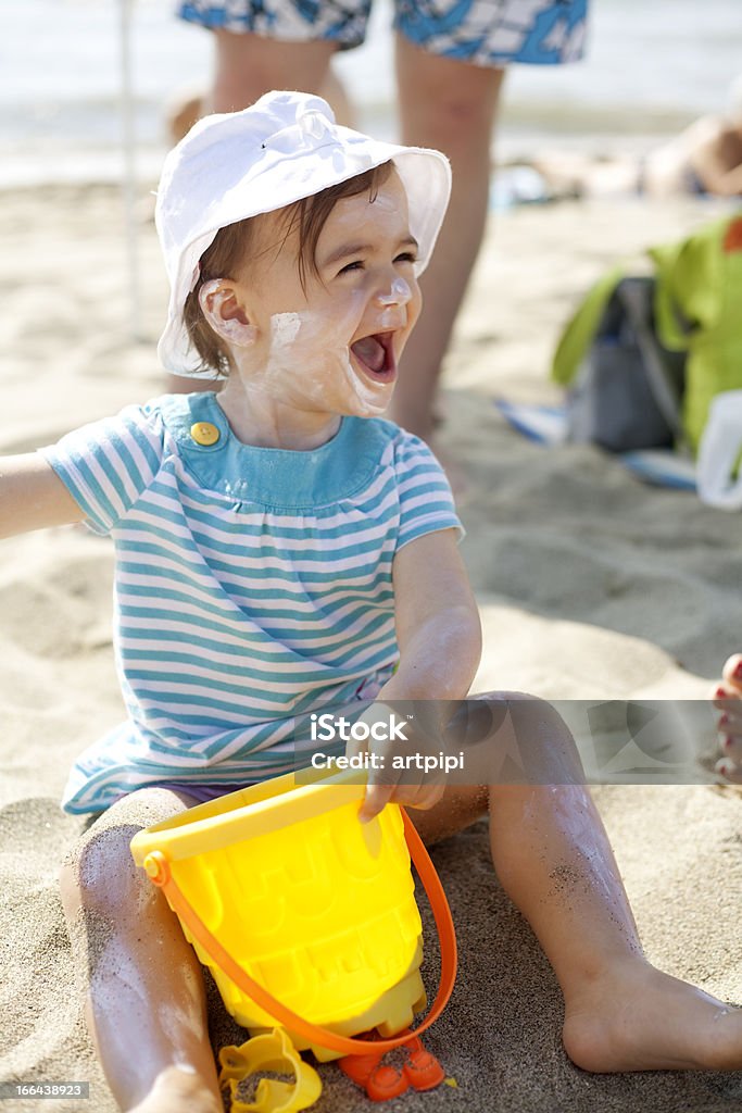 Bambina giocare nella sabbia - Foto stock royalty-free di Crema solare