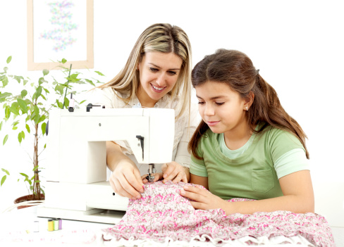 Mother and daughter sewing on a sewing machine