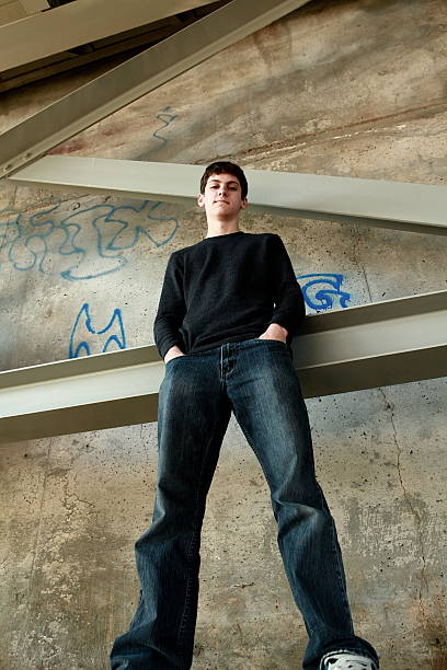 istock Teen Boy Standing By Graffitied Wall 166439081