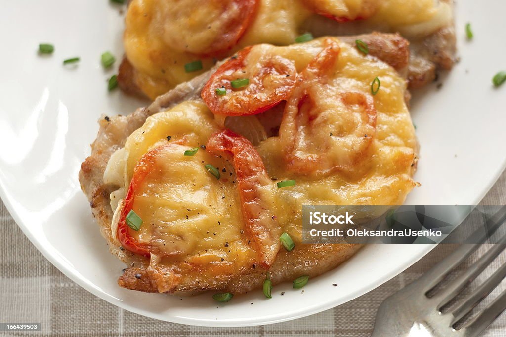 Porc et oignons, des tomates cerises et au fromage - Photo de Cuisson au four libre de droits