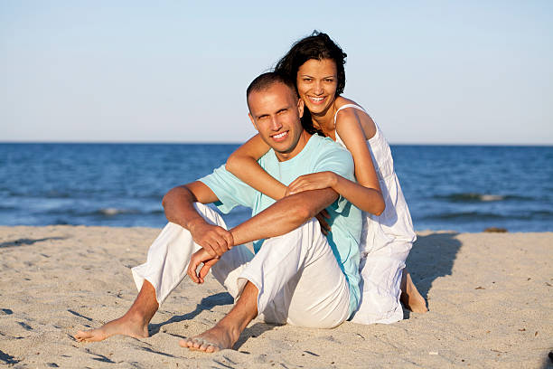 istock romantic couple sitting at beach 166439691