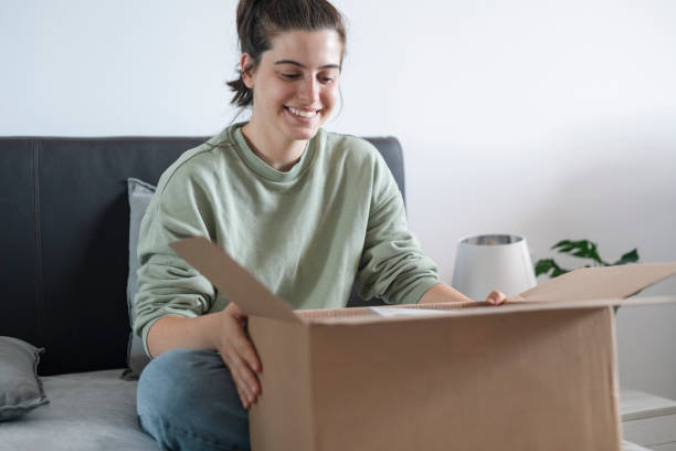 istock Happy and excisted woman opening parcel from online order. 1664416627
