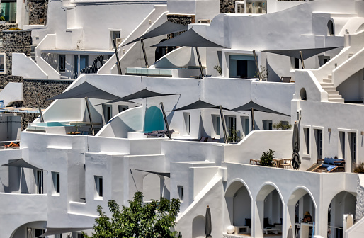 Fira, Greece - July 20, 2023: Cliffside buildings and walkways in the town of Fira on the island of Santorini in Greece