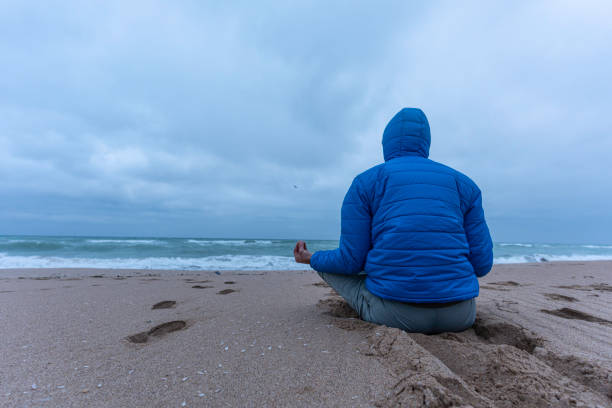 istock People and nature. Man meditating at seaside. copy space 1664430336