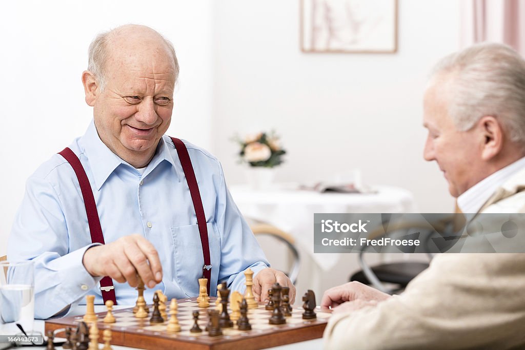 Senior men playing chess Nursing home: Senior men playing chess, focus on face Chess Stock Photo