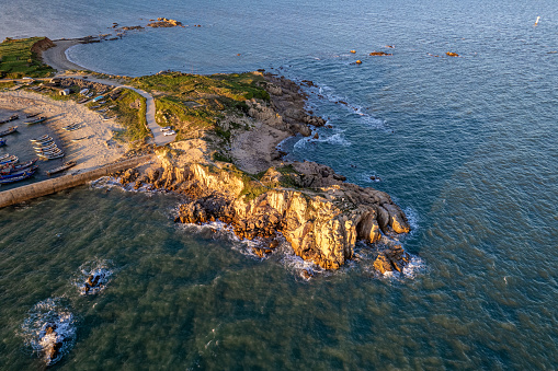 Aerial view of the protruding island in the sea at sunset