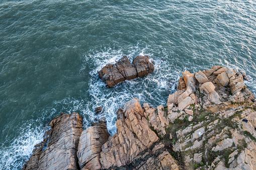 Vertical aerial view of the reefs and waves by the seaside