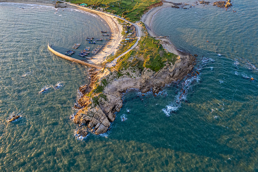 Aerial view of the protruding island in the sea at sunset