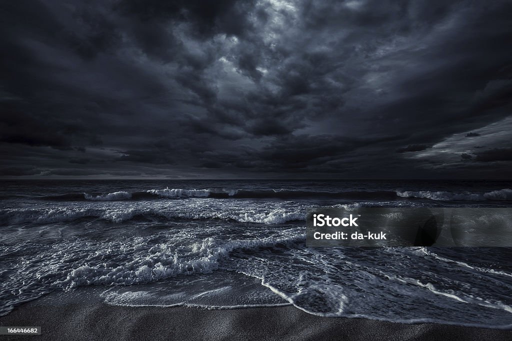 Stormy sea Shot of stormy sea and rocks against. Dark Stock Photo