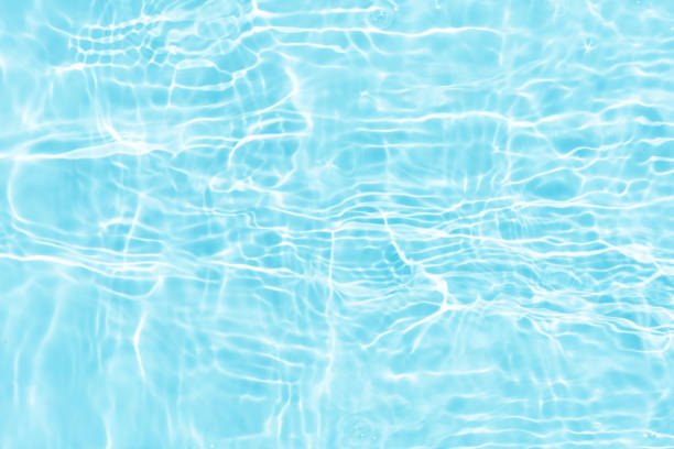 istock Blue water with ripples on the surface. Defocus blurred transparent blue colored clear calm water surface texture with splashes and bubbles. Water waves with shining pattern texture background. 1664481379