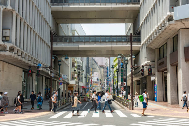 In Tokyo, Japan people walking use the crosswalk to go across the street in Shibuya.