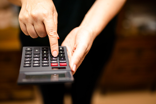 Group businessman hand using calculator Calculating bonus(Or other compensation) to employees to increase productivity.Writing paper on desk.Selective Focus