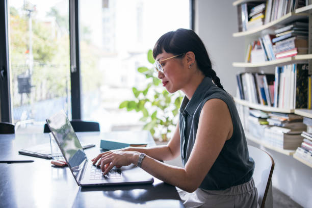 istock A Happy Beautiful Asian Businesswoman With Glasses Using Her Computer While Working In The Office 1664543934