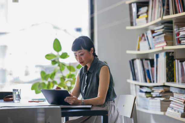 istock A Happy Beautiful Asian Businesswoman Using Her Tablet While Working In The Office 1664544483