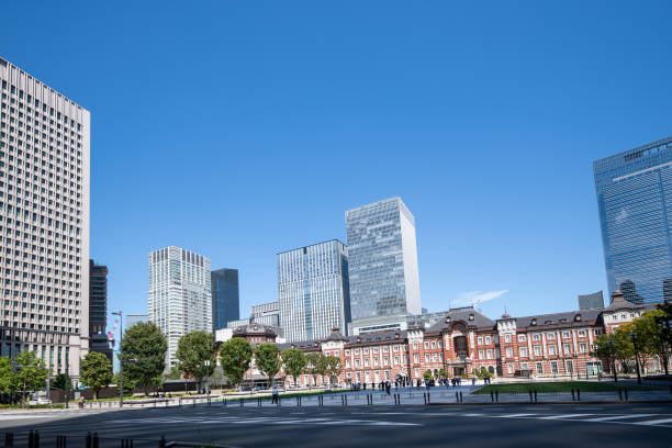 exterior view of tokyo station from above he tracks in tokyo, japan on a sunny and partly cloudy day with skyscrapers in the background along with the tokyo skyline - tokyo station railroad station chiyoda ward building exterior imagens e fotografias de stock