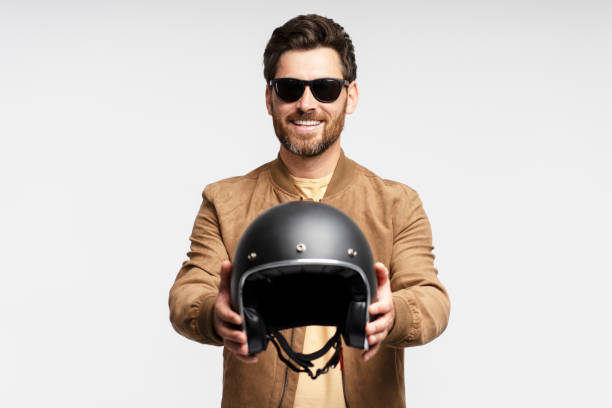 istock Handsome smiling bearded man biker holding motorcycle helmet and posing 1664568643