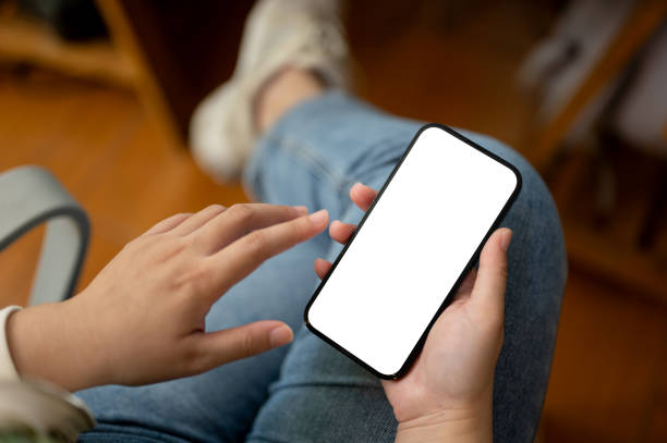 istock Close-up image of a female in jeans using her smartphone while sitting in a room. 1664629274