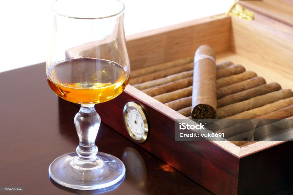 Cigars and rum Fine Cuban cigars and glass of rum on wooden table Rum Stock Photo