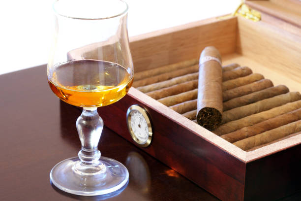 Cigars and rum Fine Cuban cigars and glass of rum on wooden table hygrometer photos stock pictures, royalty-free photos & images