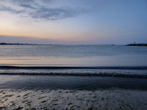 istock Calm horizon over water on coastal beach 1664645300