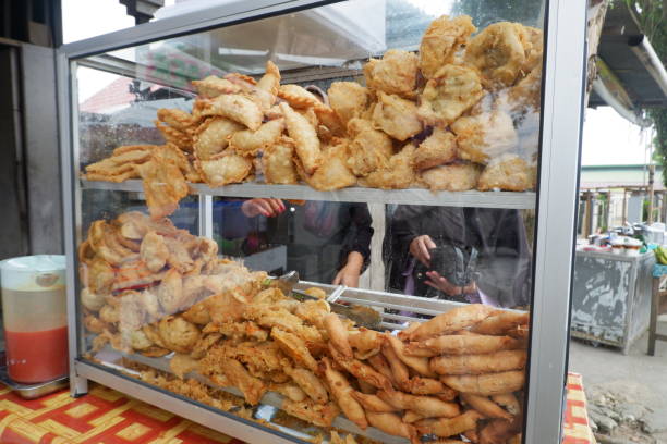 various types of snacks that are fried and sold on glass display case